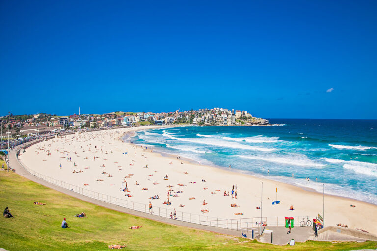 Bondi Beach in Sydney, Australia, with people sunbathing and swimming.