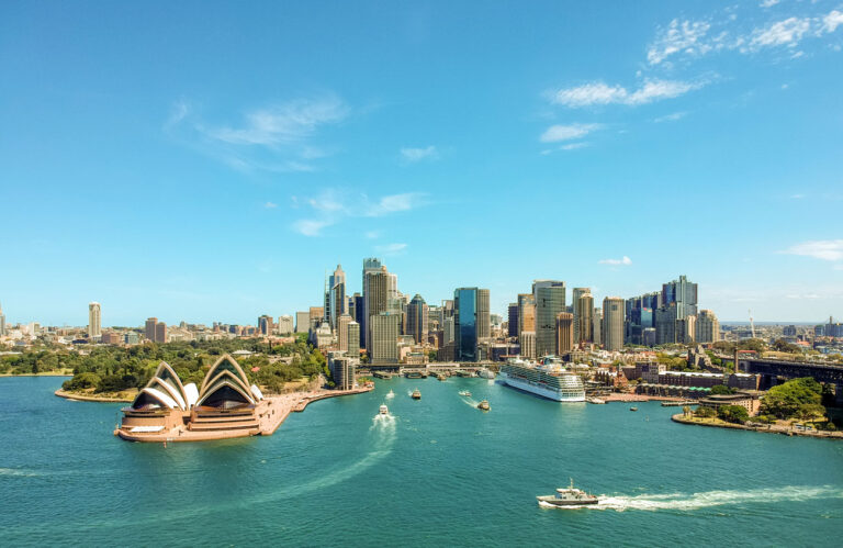 Sydney Opera House and city skyline by the water.