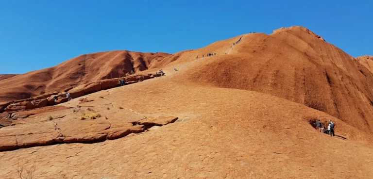 Hikers climbing Uluru in Australia.