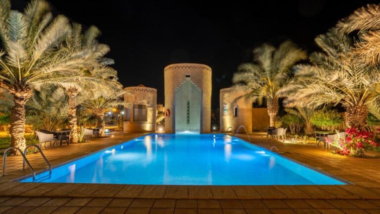 Night view of a hotel pool with palm trees in Morocco