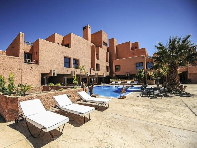 Hotel pool with lounge chairs and palm trees in Morocco.