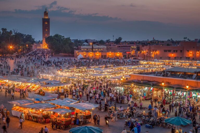 Jemaa el-Fna market in Marrakesh at night with bustling crowds.