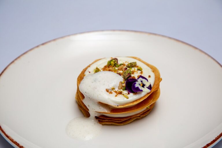 Layered Moroccan dessert with cream and pistachios
