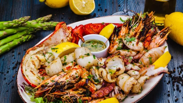 A platter of grilled seafood with lemon and asparagus.