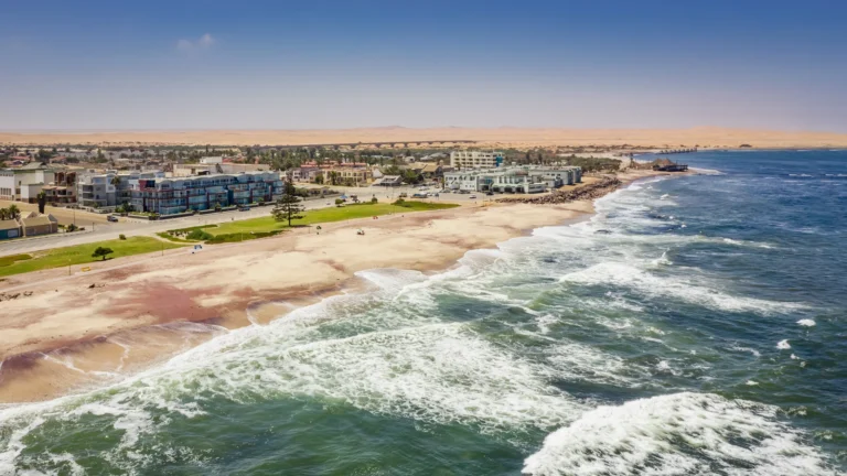 Swakopmund coastline with ocean waves and urban buildings.