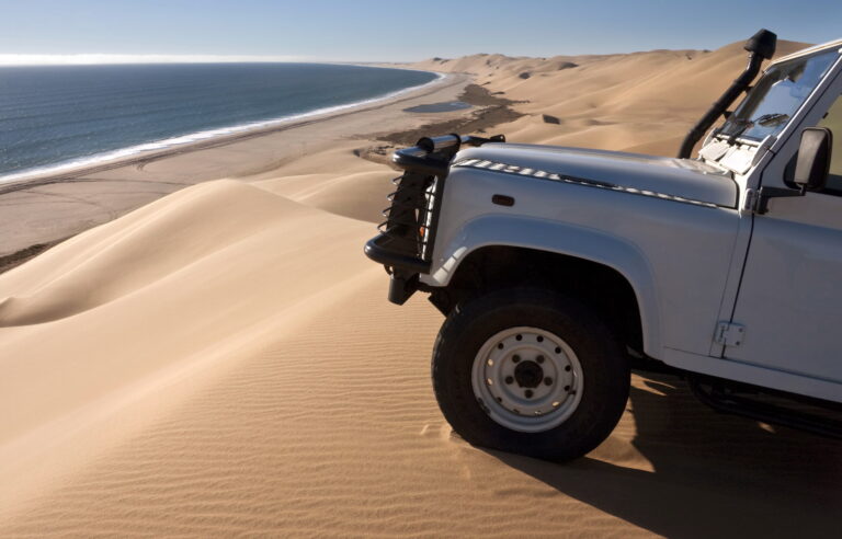 Off-road vehicle on sand dunes by the coast