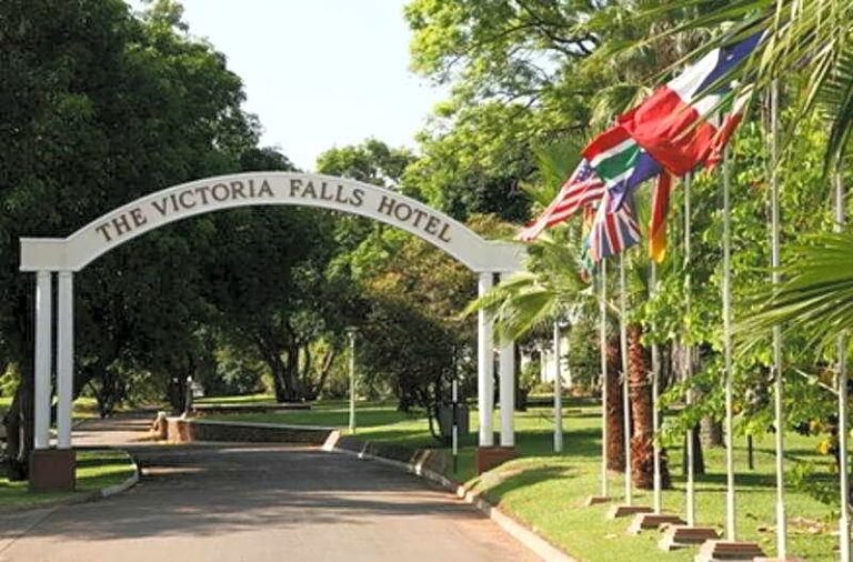 Entrance to The Victoria Falls Hotel with flags and pathway
