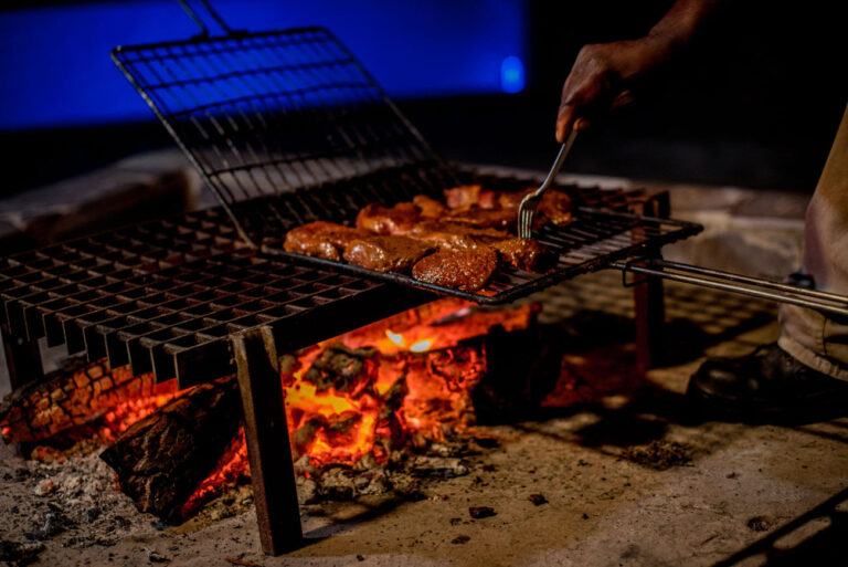 Grilling meat over an open fire at a BBQ restaurant.