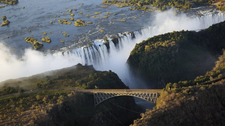 Aerial view of Victoria Falls with mist and bridge
