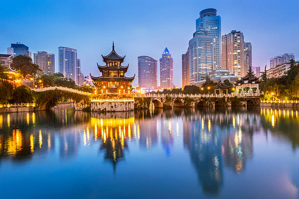 Jiaxiu Tower in Guiyang with modern skyline at dusk