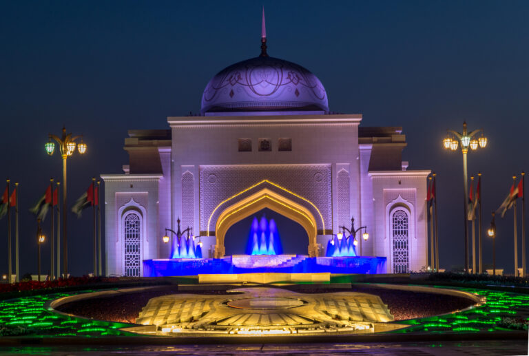 Qasr Al Watan illuminated at night with fountains in Abu Dhabi.