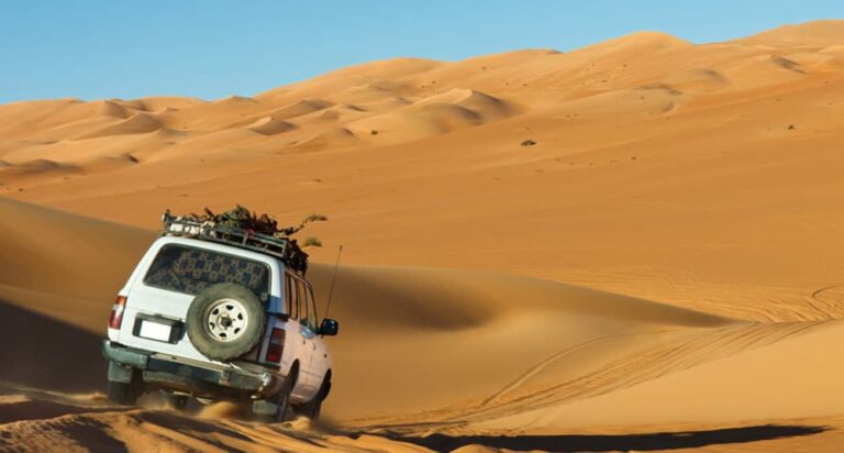 Jeep driving through Dubai desert sand dunes