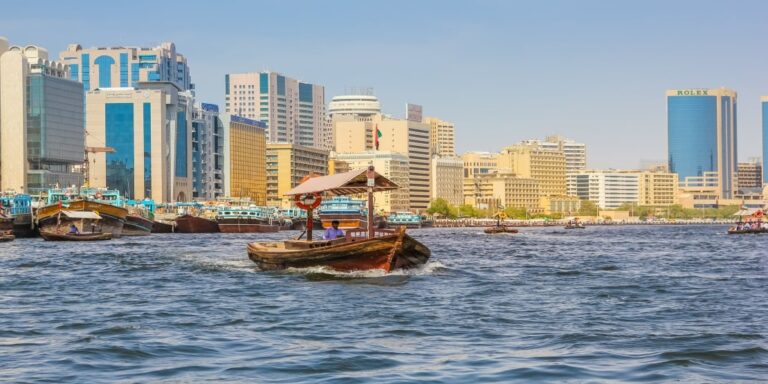 Traditional abra on Dubai Creek with city skyline