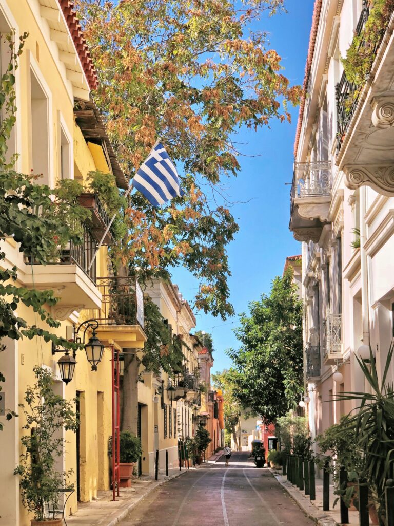 Charming street in Plaka, Athens with Greek flag