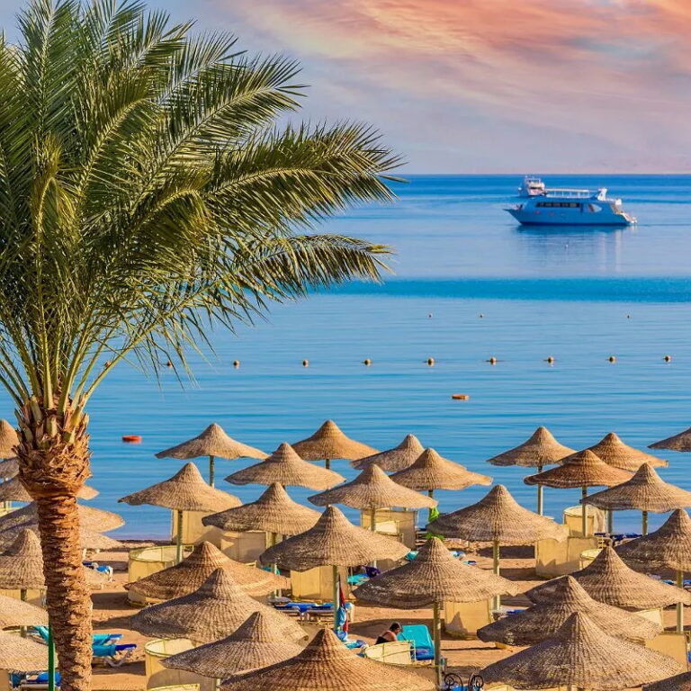 Beach with palm trees and umbrellas in Hurghada, Egypt
