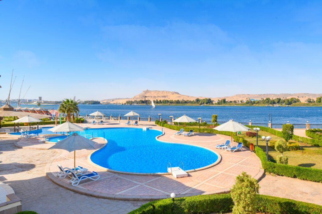 Poolside view at Aswan Tolip Hotel overlooking the Nile River.