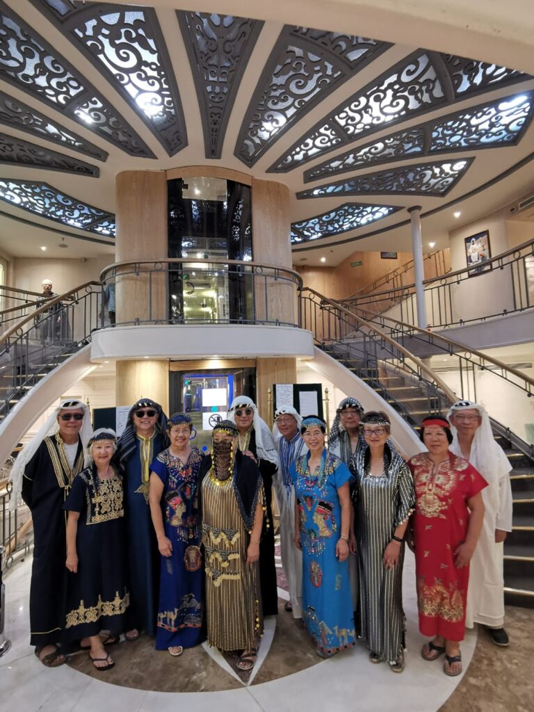 Group of GoGo Tours travelers in traditional Egyptian attire on a Nile cruise.