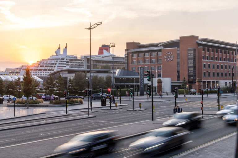 Crowne Plaza Hotel in Liverpool city center with a cruise ship in the background.