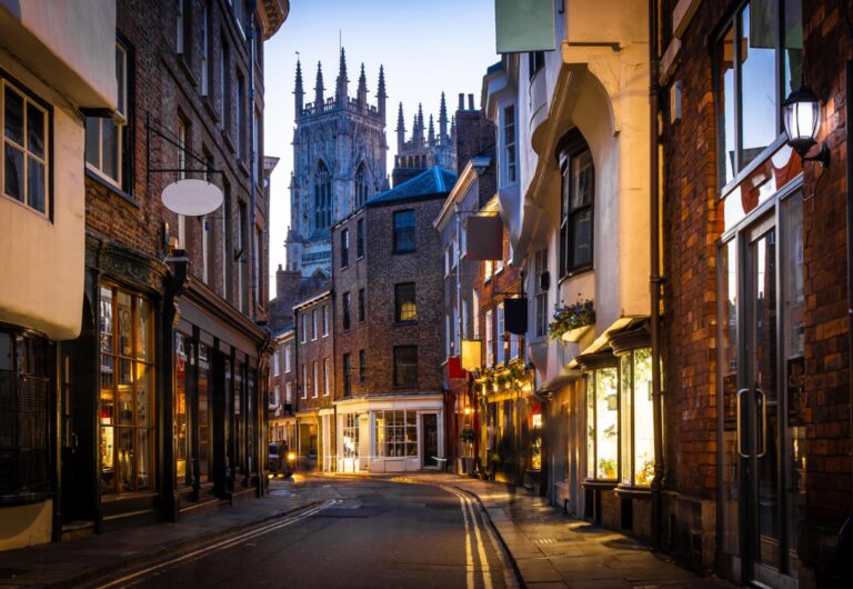 A picturesque street in York with historic buildings and York Minster in the background.