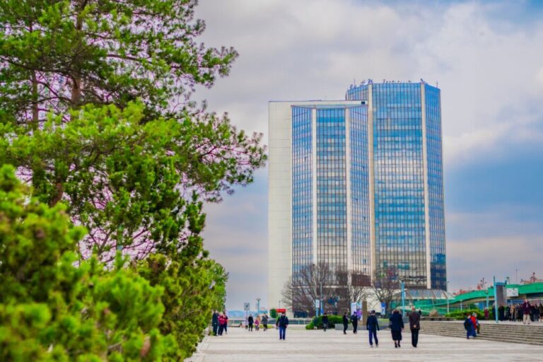 Modern skyscraper in Prague with people walking nearby