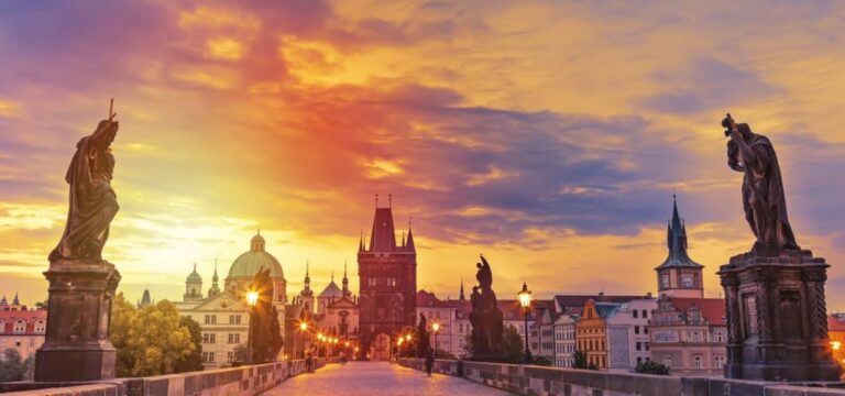 Charles Bridge in Prague at sunset with statues.