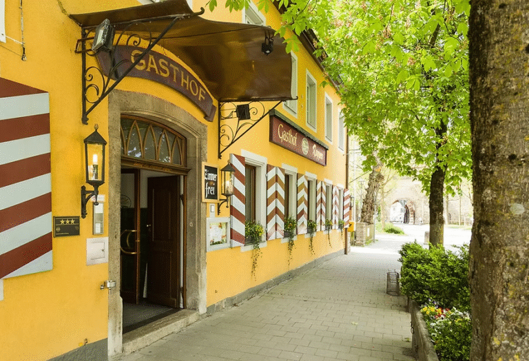 Bavarian inn Gasthof Rappen with yellow facade and sidewalk.