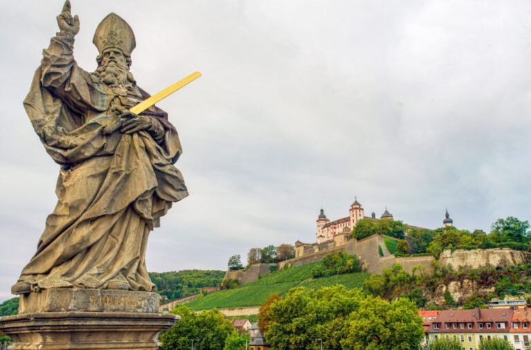 Statue of Saint Kilian with Marienberg Fortress in the background.