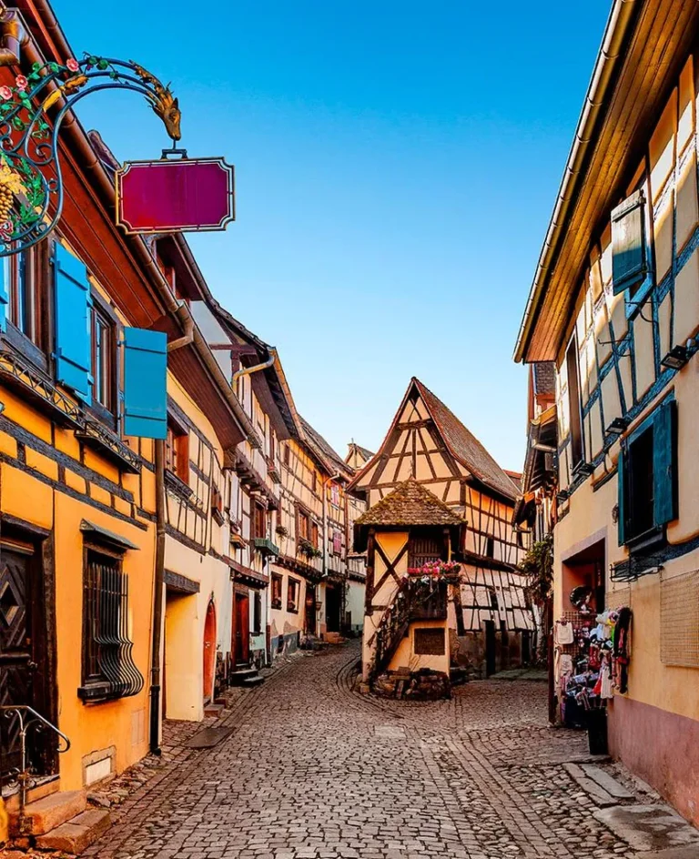 Quaint street in Eguisheim, France with half-timbered houses