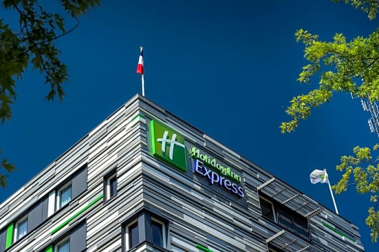 Modern Holiday Inn Express hotel with sleek design and flags