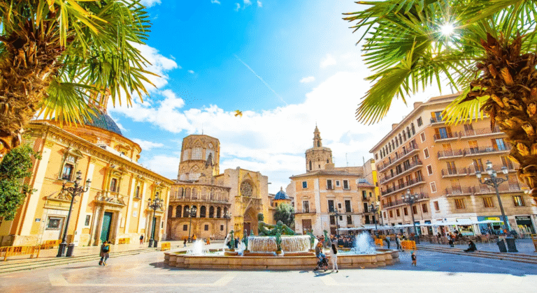 Valencia Cathedral and Plaza de la Virgen with fountain and palm trees.