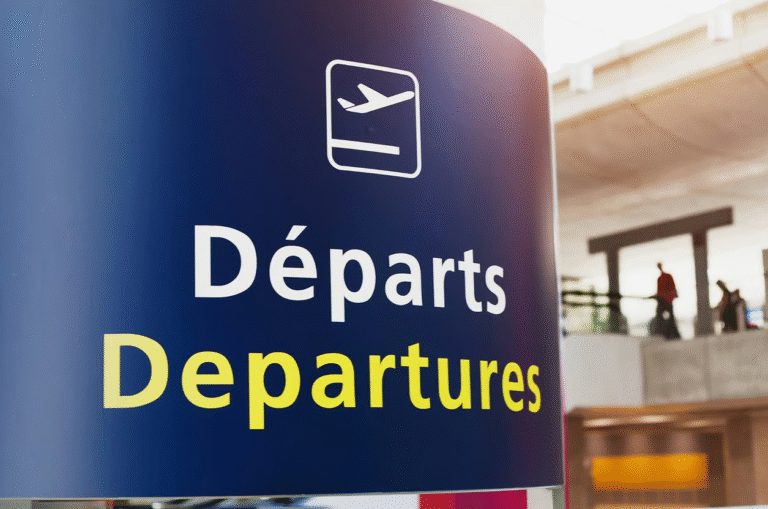 Departures sign at Paris airport in French and English.