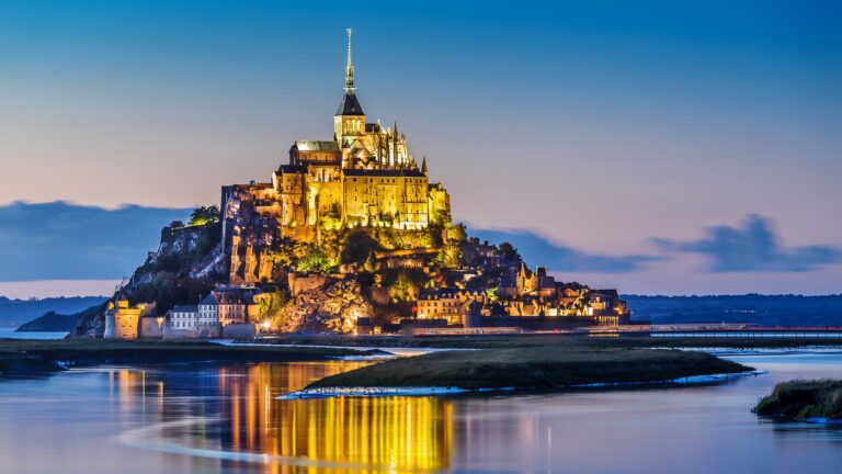 Mont Saint-Michel at dusk with reflections in water