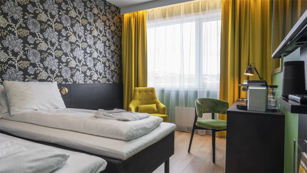 Modern hotel room with floral wallpaper and yellow accents