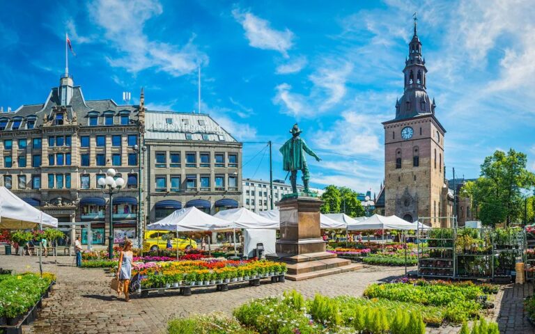 Oslo flower market with statue and church tower