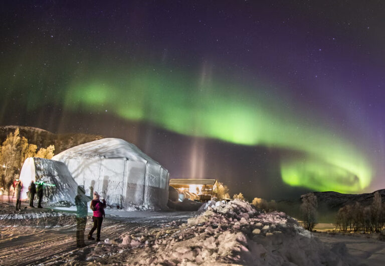 Northern Lights over snowy igloo in Kirkenes.