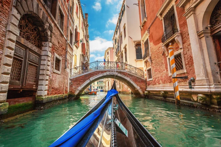 Gondola ride through a Venetian canal under a bridge.