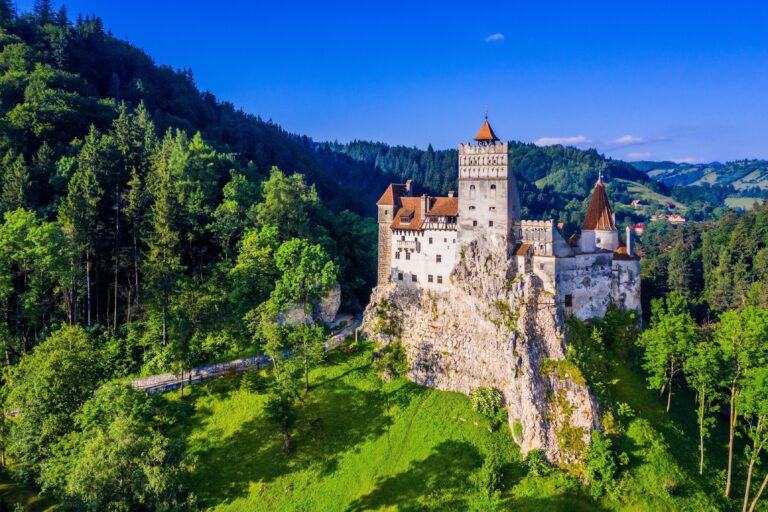 Bran Castle in Romania surrounded by lush greenery