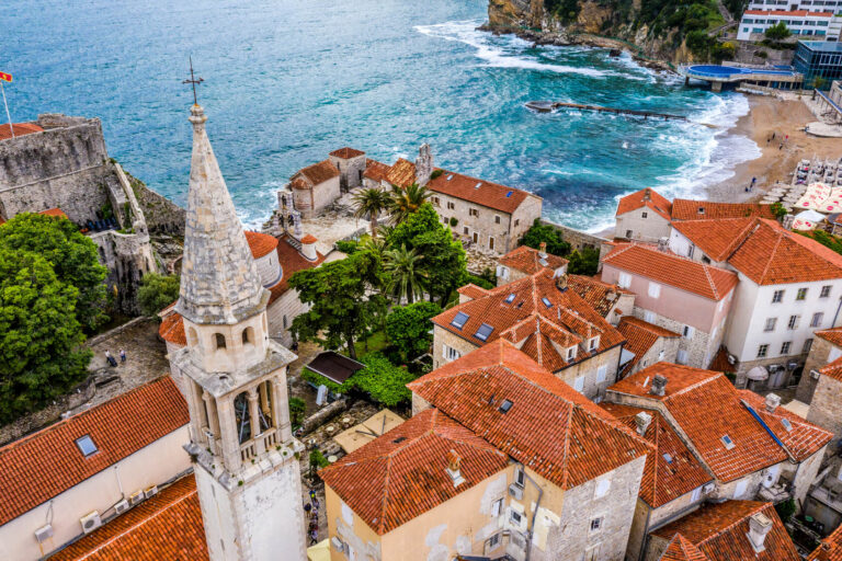 Aerial view of Budva Old Town with red rooftops and the Adriatic Sea.