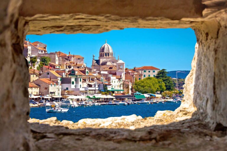 View of Sibenik's historic architecture and dome from a stone window.