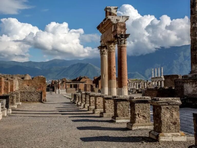 Ancient ruins in Pompeii with mountains in the background
