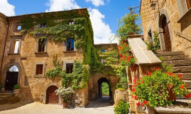 Historic stone buildings with ivy and flowers in Civita di Bagnoregio.
