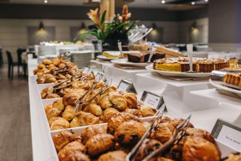 Hotel breakfast buffet with pastries and cakes.