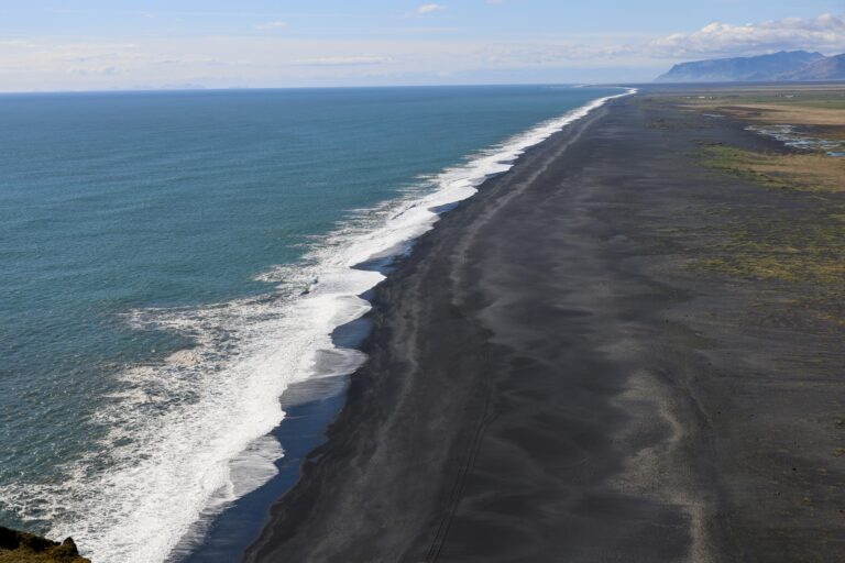 Black sand beach with ocean waves.