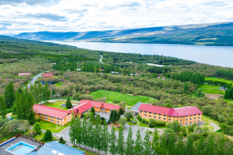 Aerial view of Hallormsstadur hotel in Iceland with lake and forest.