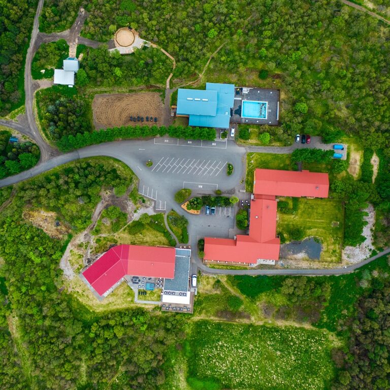 Aerial view of Hotel Hallormsstaður in Iceland surrounded by lush greenery.