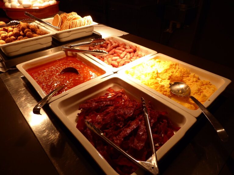 Breakfast buffet with eggs, pancakes, and sausages
