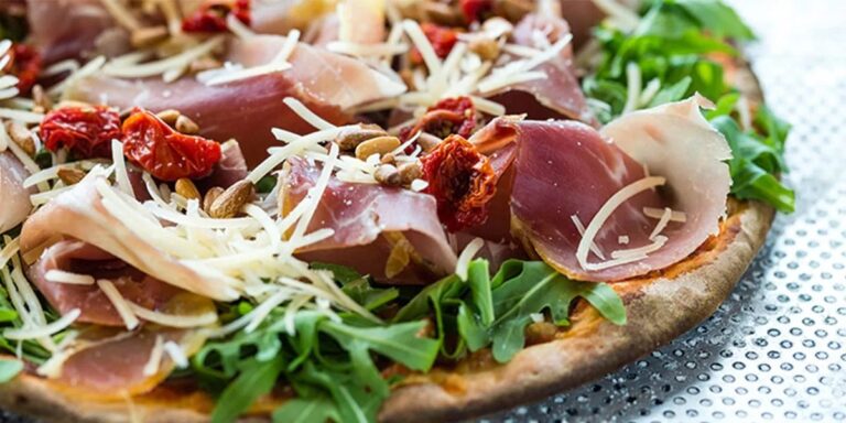 Gourmet pizza with prosciutto and arugula