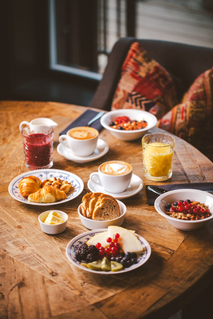 Cozy breakfast spread with coffee, juice, pastries, and fruits.