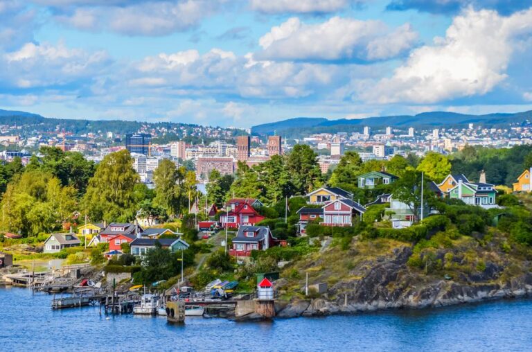 Colorful houses on the Oslo waterfront with the city skyline.