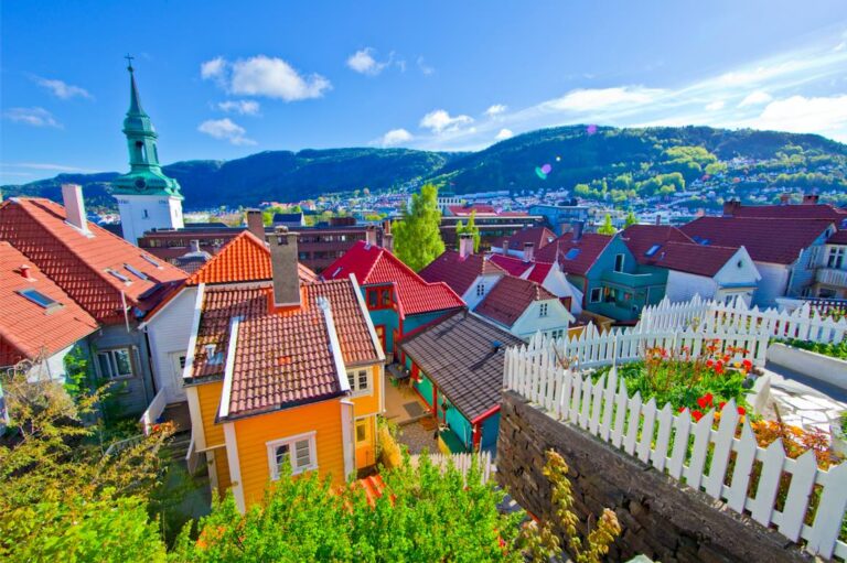 Colorful rooftops in Bergen, Norway with a church and mountains in the background